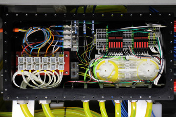 A pressure-tolerant junction box with electrical and fiber optic equipment